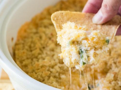 Baked jalapeño popper dip on a tortilla chip.