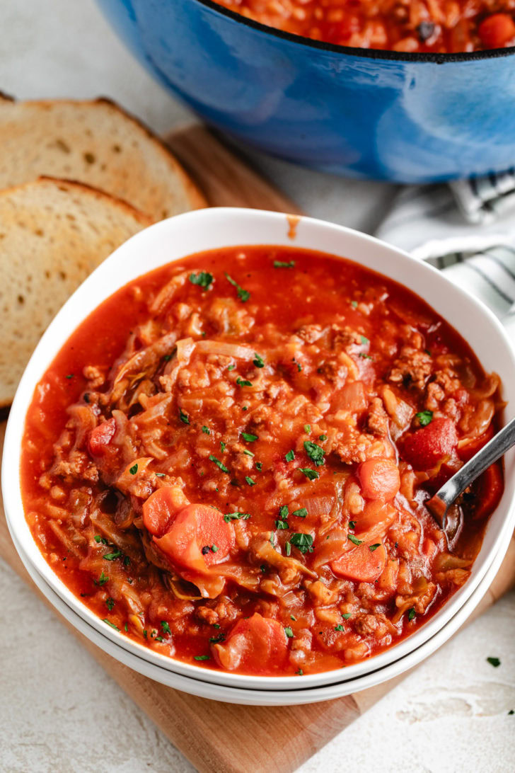 A white bowl of hearty tomato and cabbage soup.
