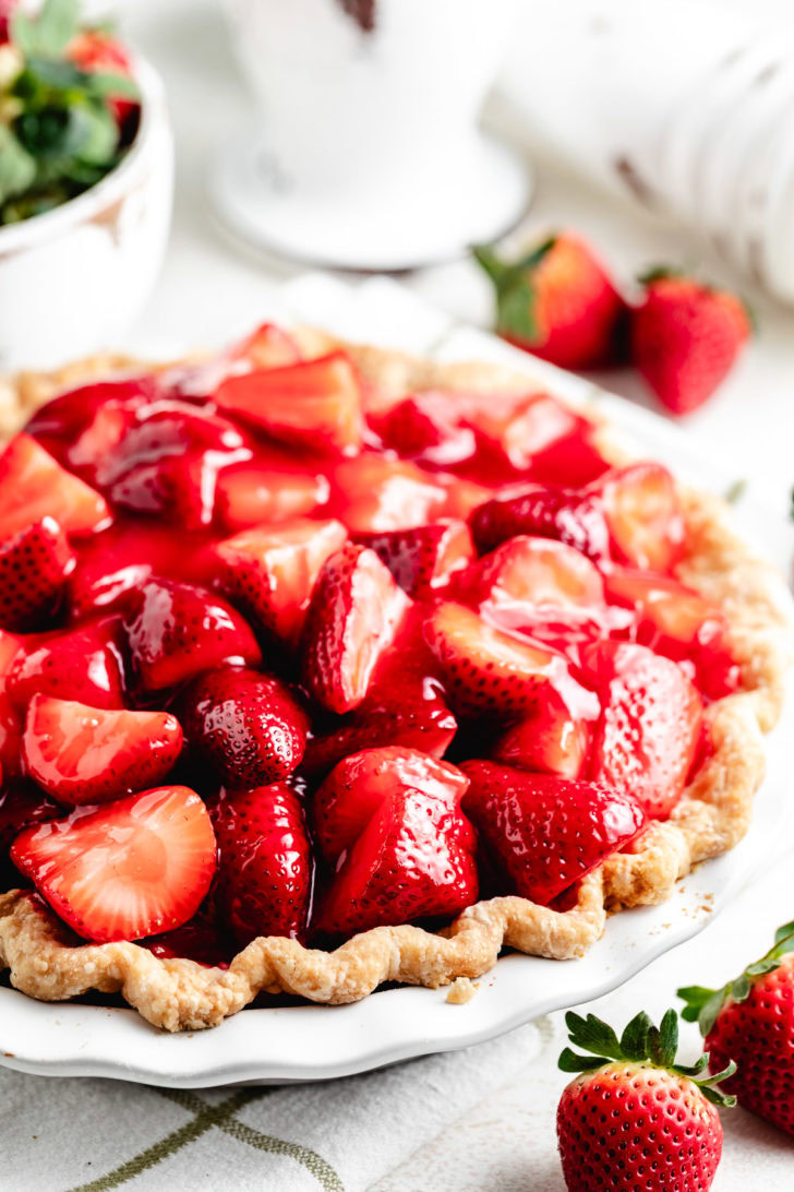 Side view of glazed strawberries in a flaky pie crust.