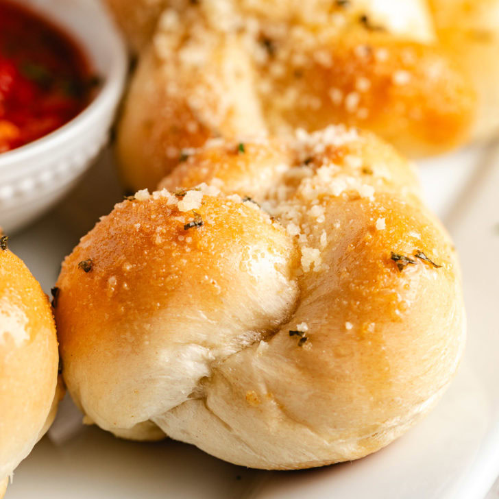 Close up of buttery garlic knots with Parmesan.