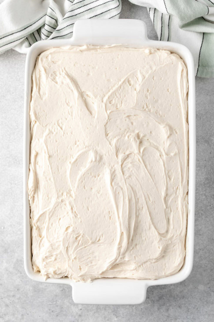 Rectangular pan of cake generously coated with creamy Baileys buttercream frosting.