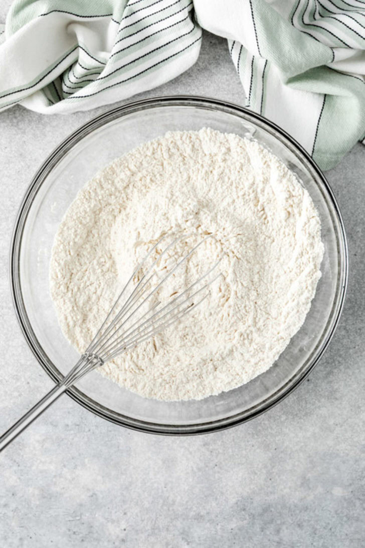 Large glass bowl of whisked flour and leavening ingredients for the dry mix of the chocolate cake.