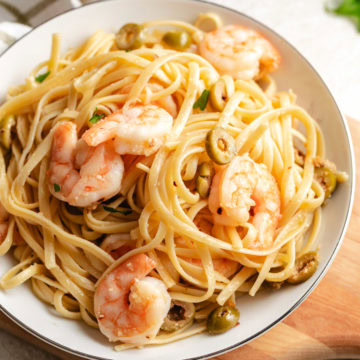 Bowl of mediterranean shrimp pasta with green olives.