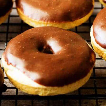 Close up view of a vanilla donut on a wire rack.