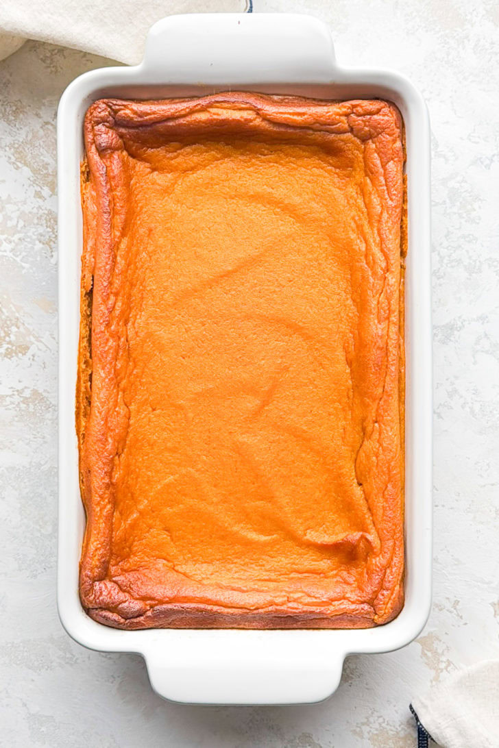Carrot soufflé bakes in a white casserole dish.