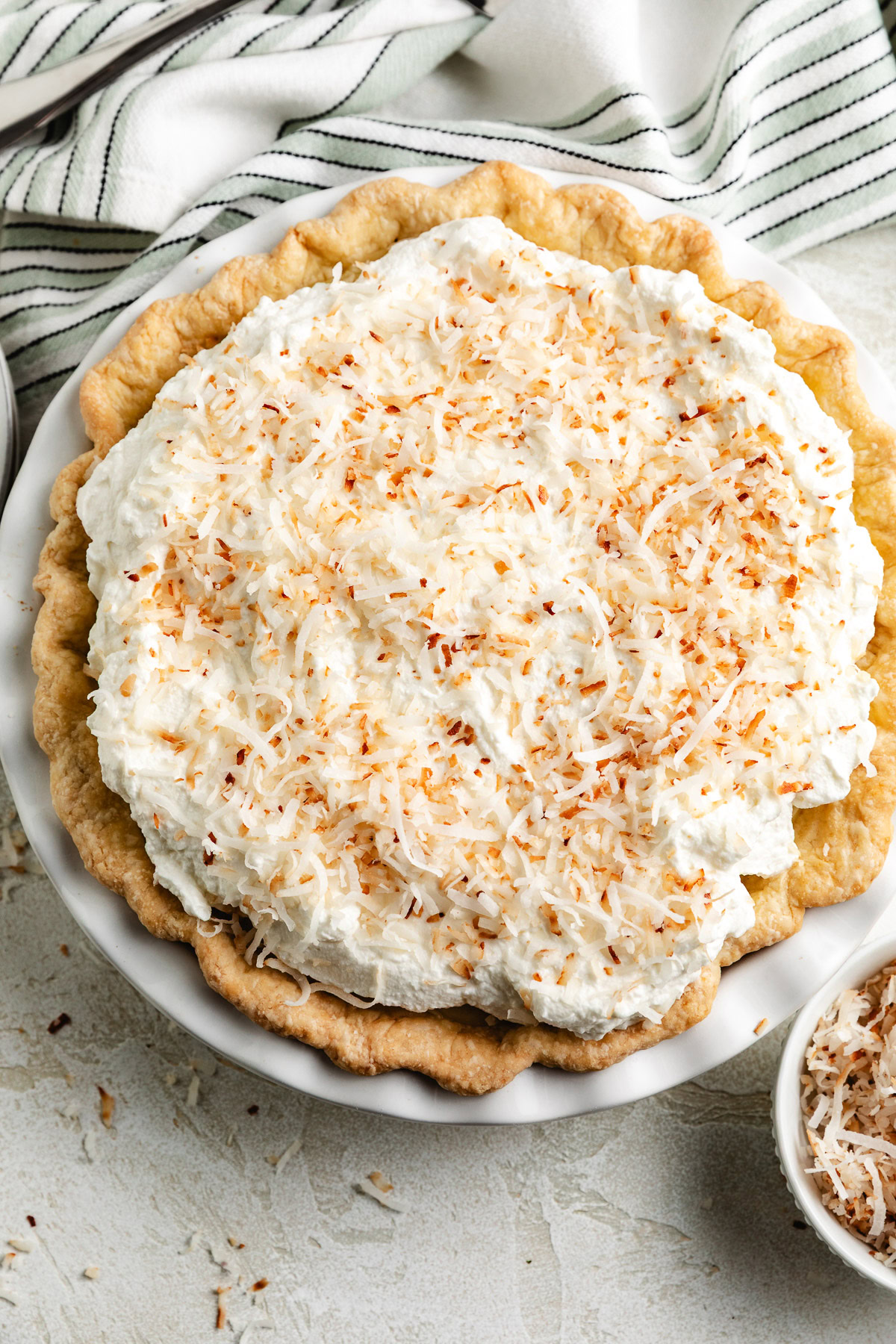 Coconut cream pie with whipped topping is shown from above.
