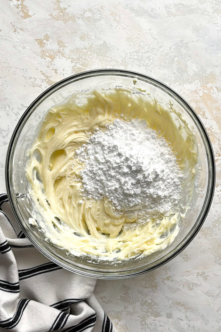 Cream cheese and powdered sugar in a bowl.