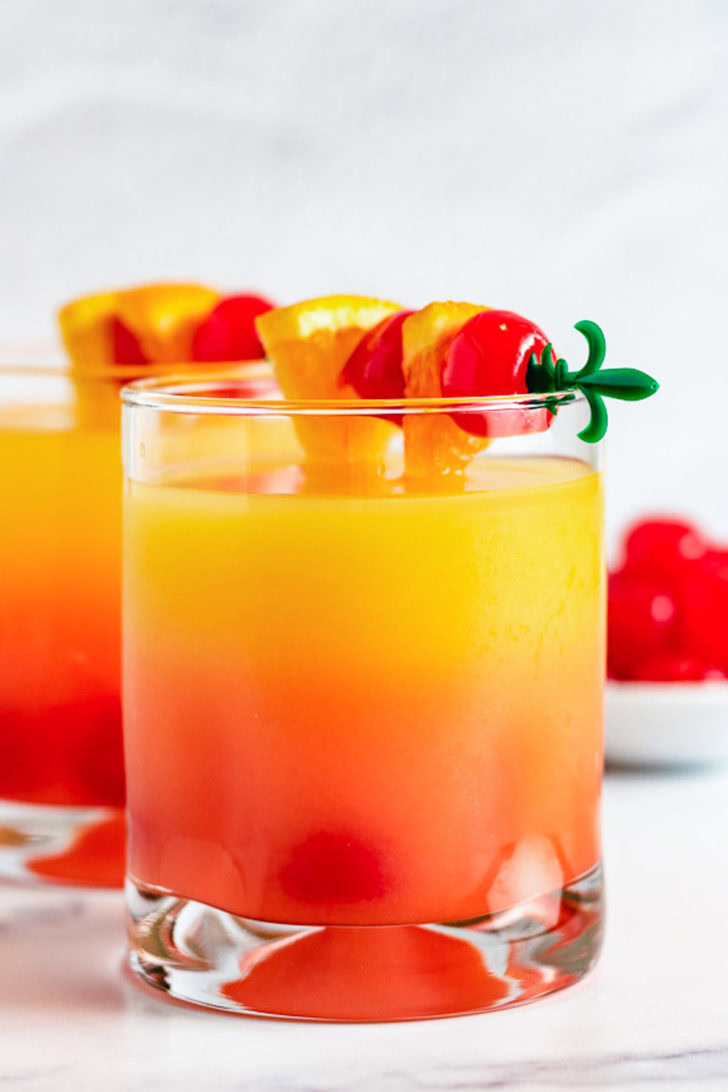 Cherries and oranges on top of a malibu sunset.