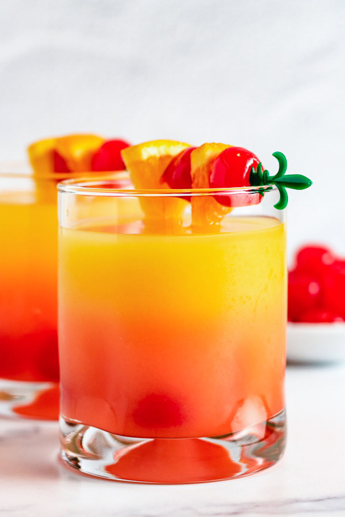 Cherries and oranges on top of a malibu sunset.