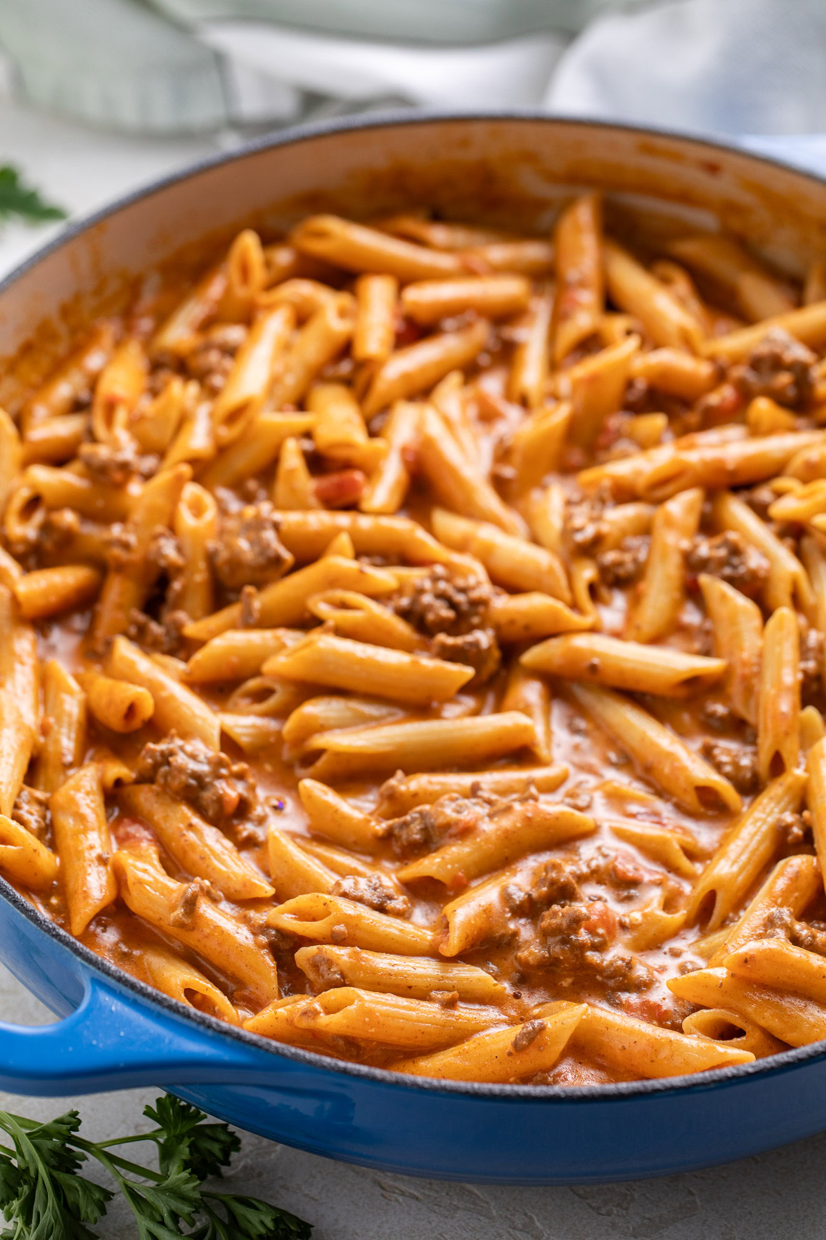 A spoonful of taco penne pasta lifted from the skillet.