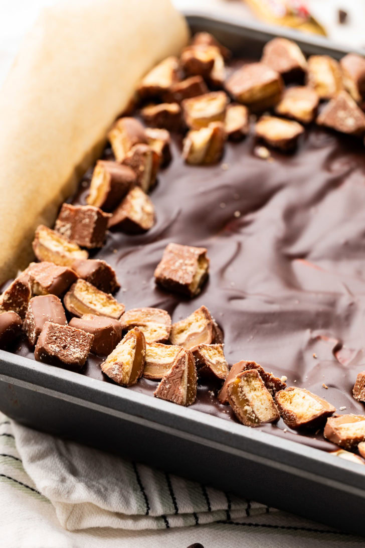 Close-up of chopped candy bars along the edge of the chocolate topping.