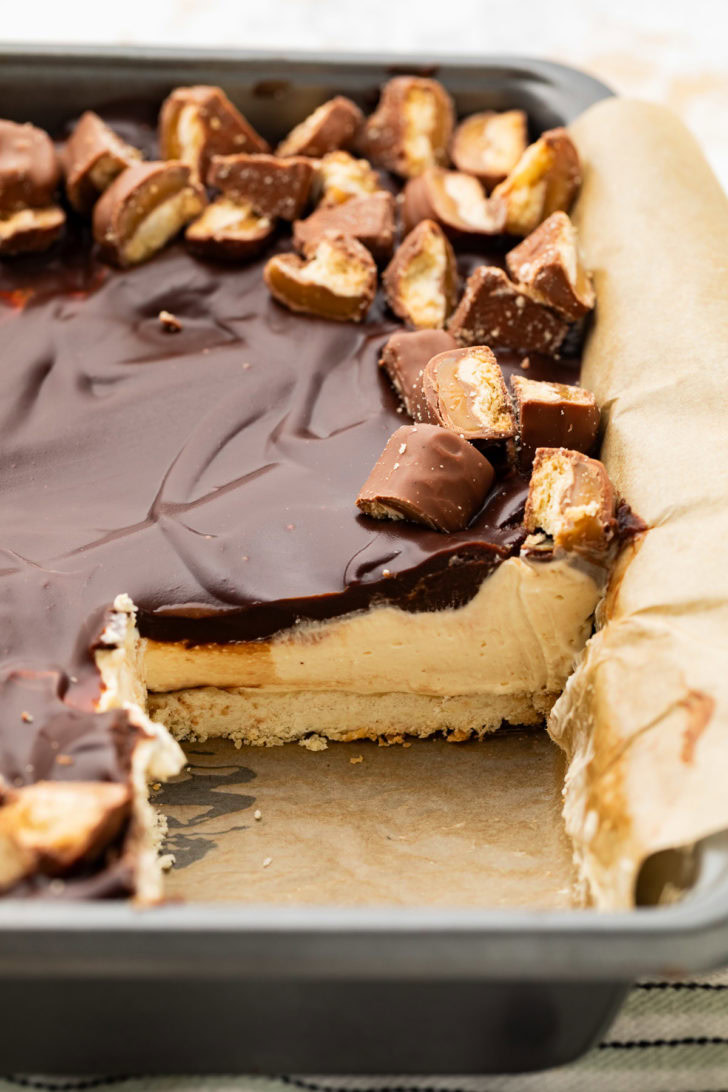 Partial pan of cheesecake bars showing the shortbread crust and caramel filling.