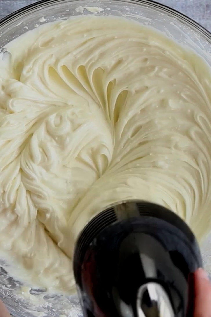 Key lime cheesecake dip being mixed in a bowl.