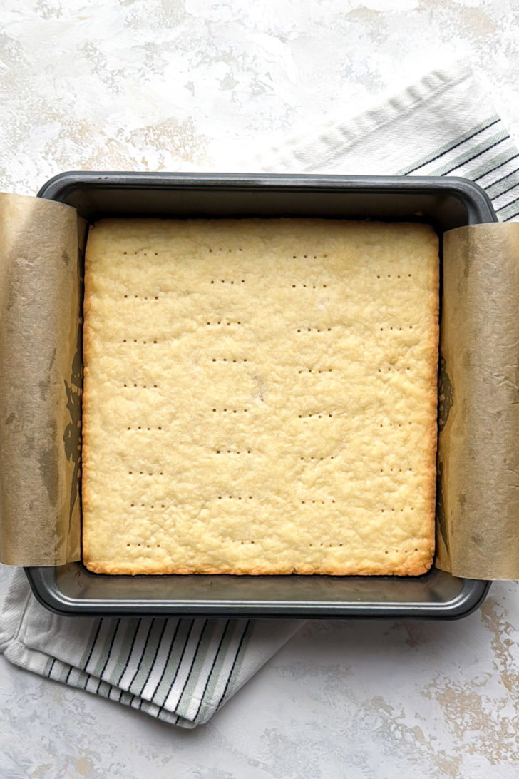 The shortbread crust is baked until lightly golden in the pan.