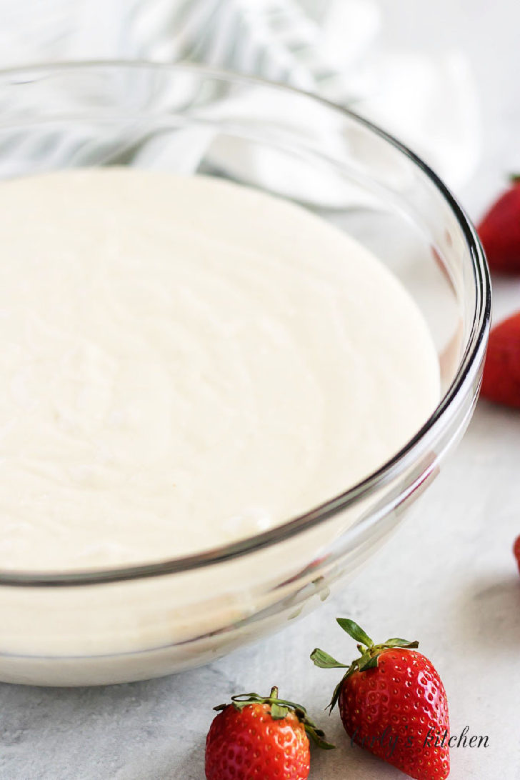 White cake batter in a glass mixing bowl for tres leches cake.