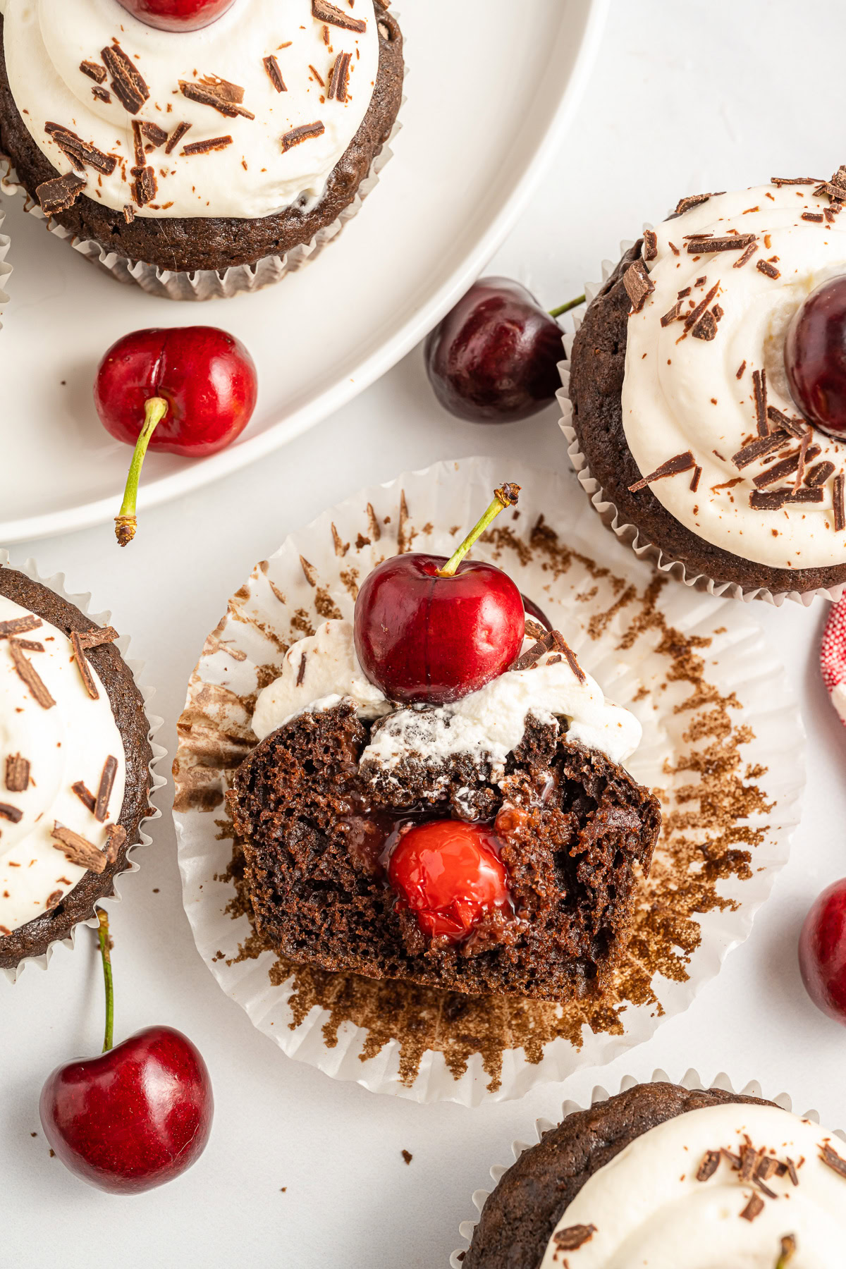Black forest cupcake cut in half laying in a cupcake wrapper.