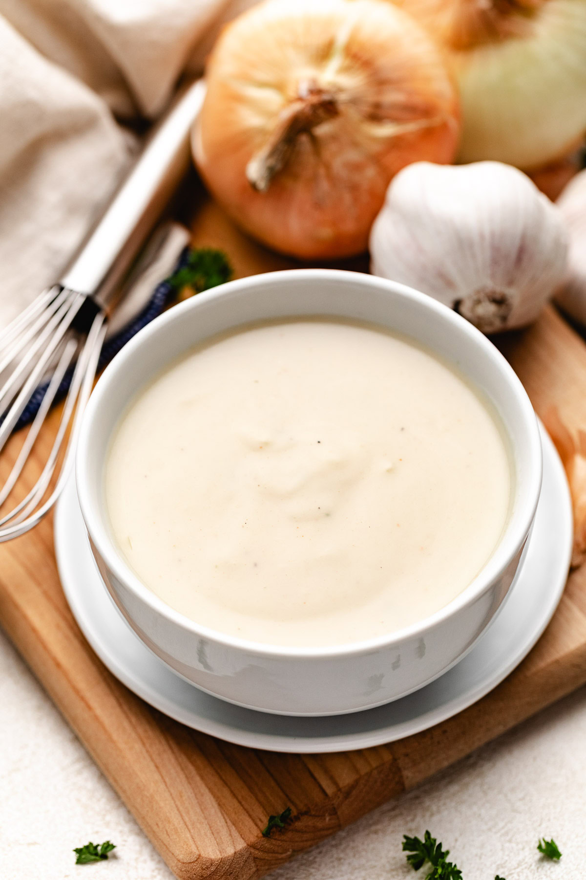 Substitute of cream of chicken soup in a white bowl on a cutting board.
