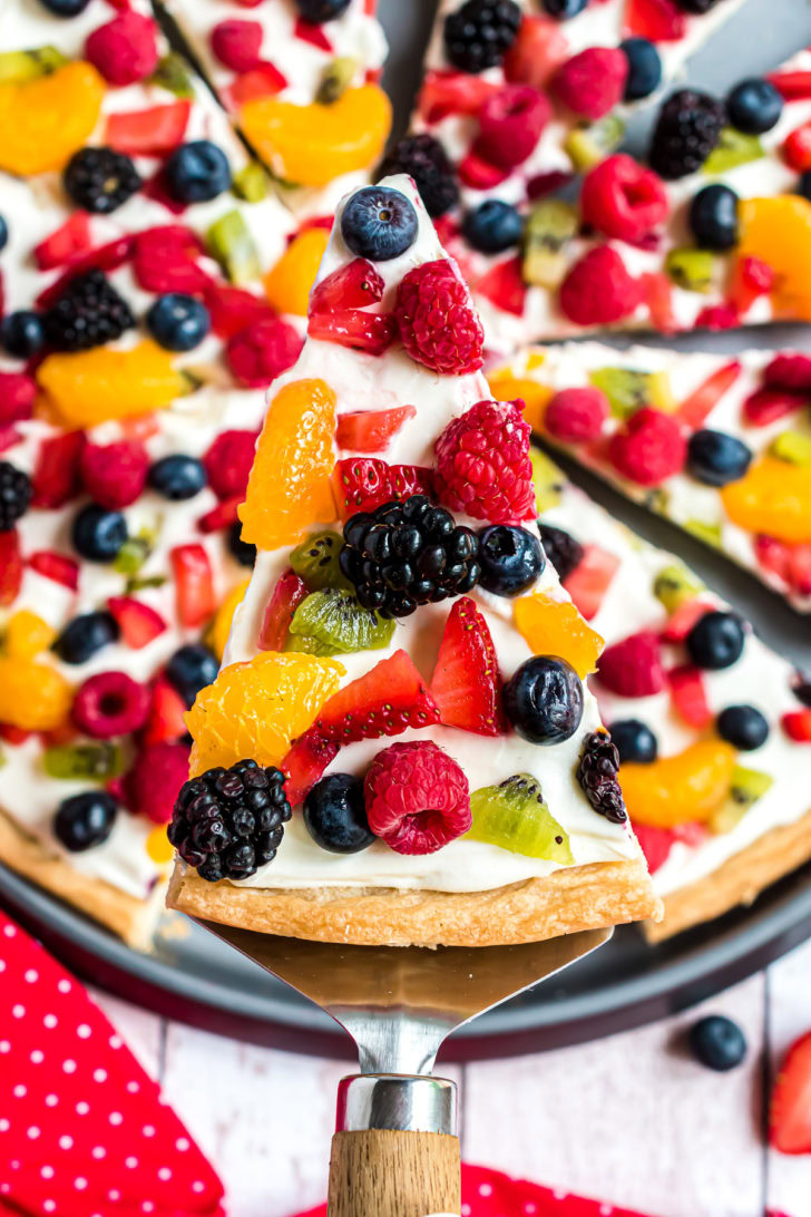 Fruit pizza slice on serving spatula.