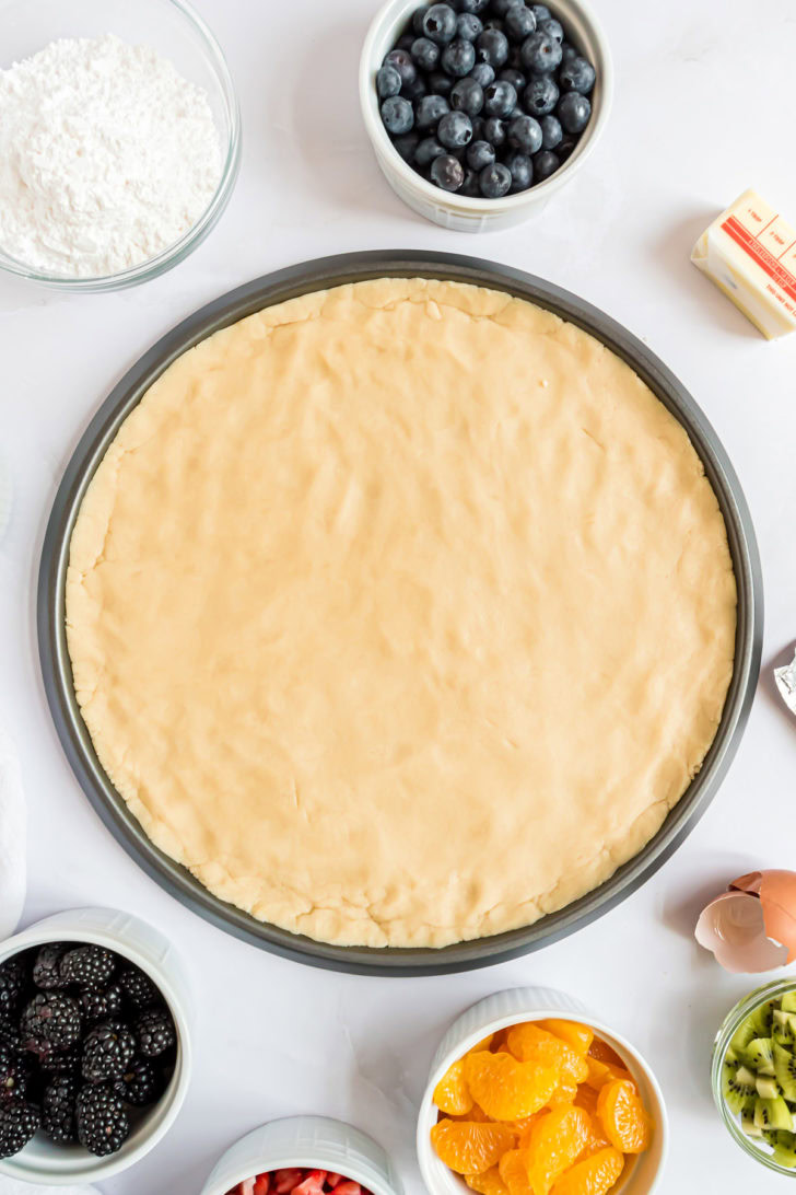 Dough pressed into round pizza pan.