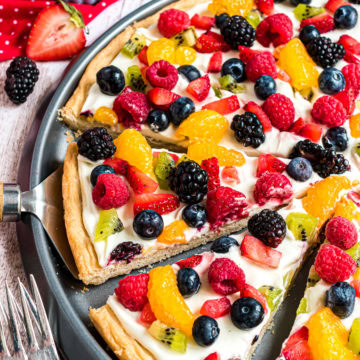 Fruit pizza slices on baking pan.