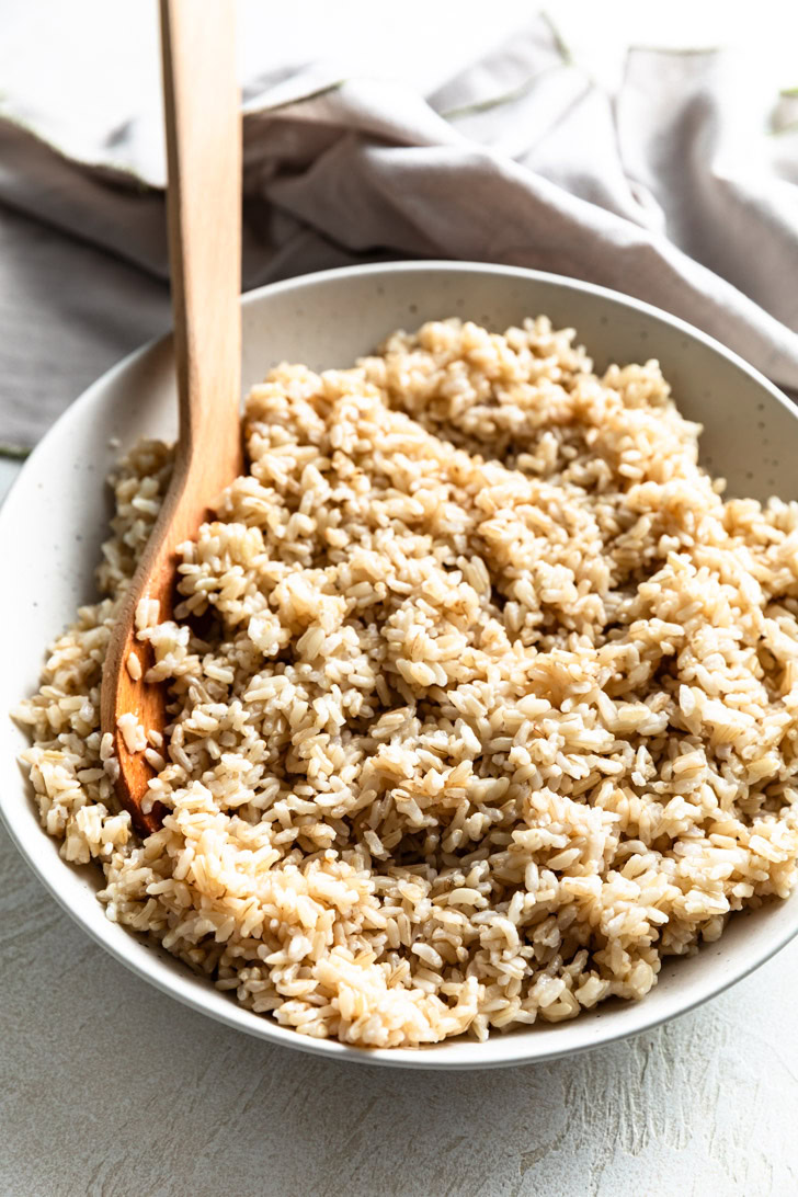 Side view of fluffy brown rice in a bowl.
