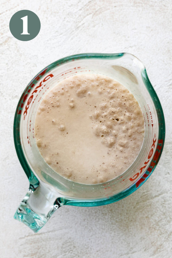 Overhead view of yeast proofing in a glass measuring cup.