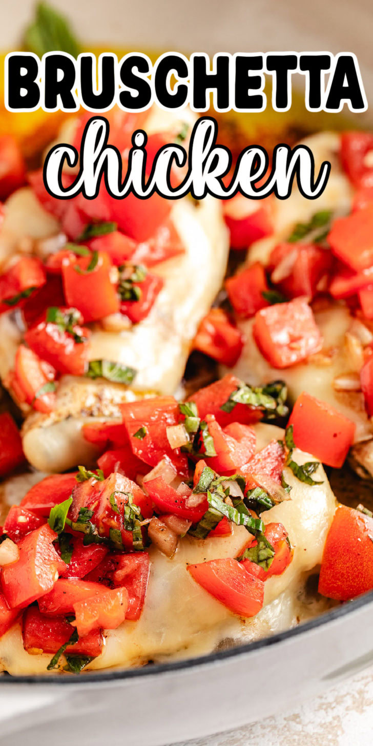 Close up view of tomato bruschetta on top of cheesy chicken.