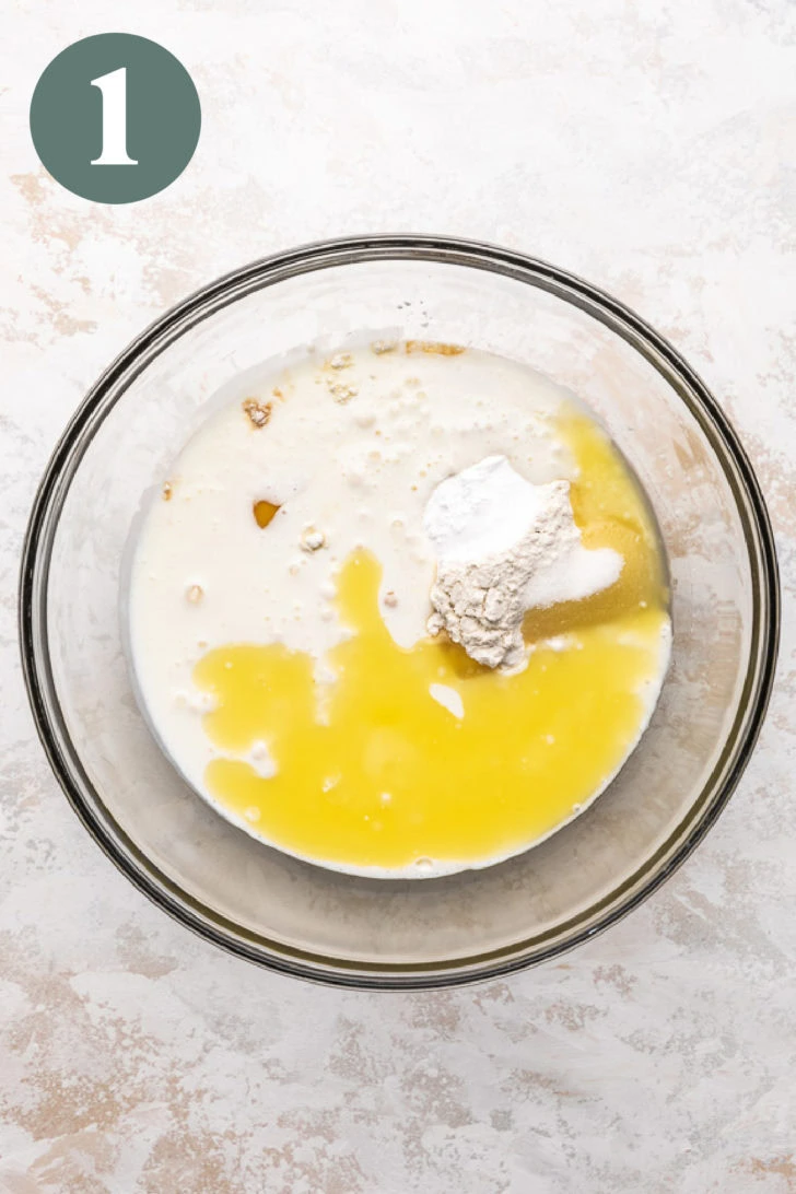 Unmixed ingredients for buttermilk pancakes in a glass mixing bowl.