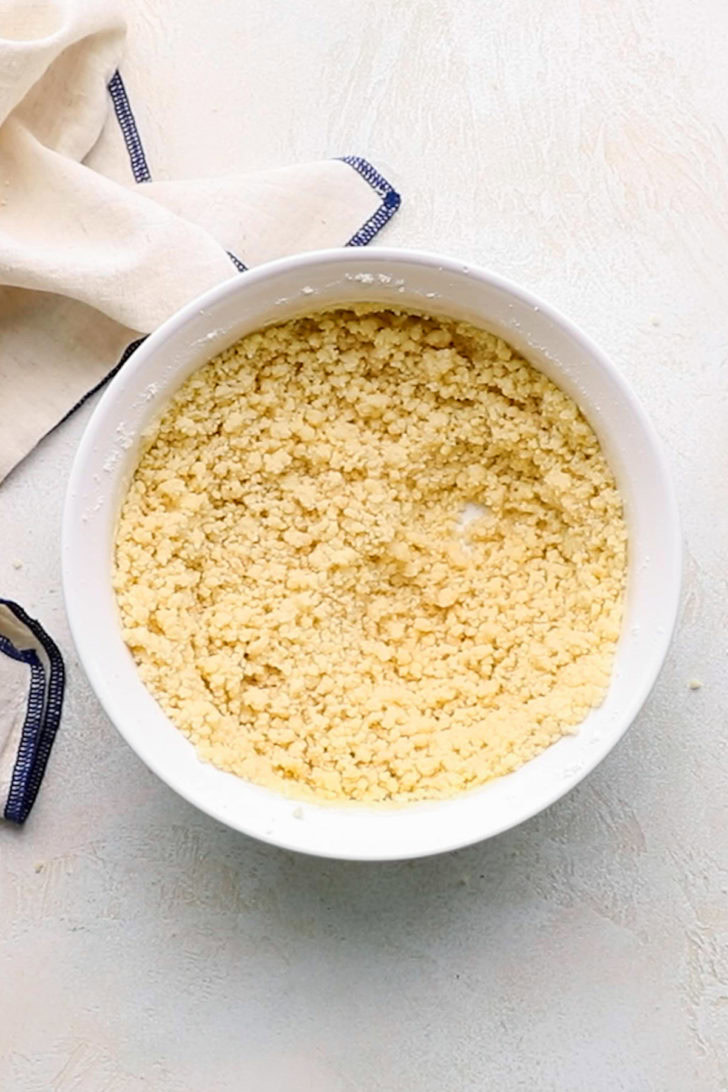 Dough for a shortbread crust mixed together in a white bowl.