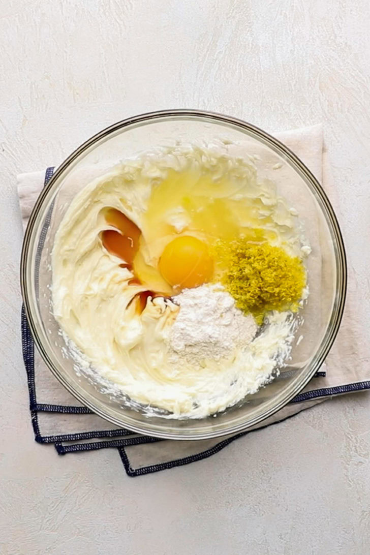 Ingredients for creamy lemon filling used in lemon raspberry crumb bars in a glass bowl.