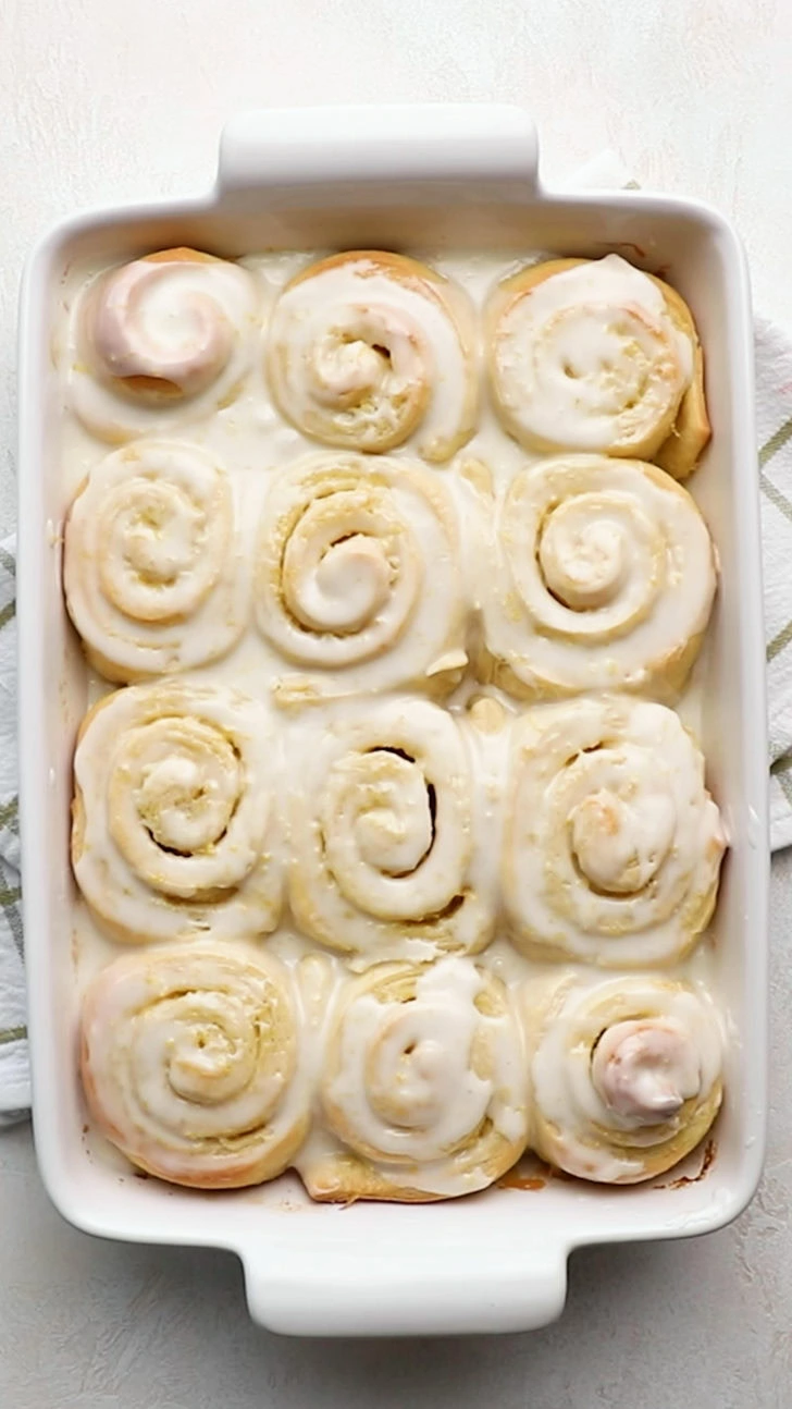 Glazed sweet rolls in white baking dish.