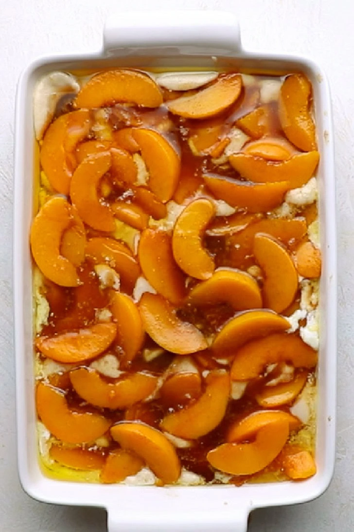 Peach filling spooned over cobbler batter before baking.