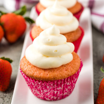 Strawberry champagne cupcakes on a white serving dish.