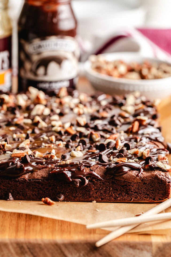 Chopped pecans and chocolate chips sprinkled over turtle brownies.