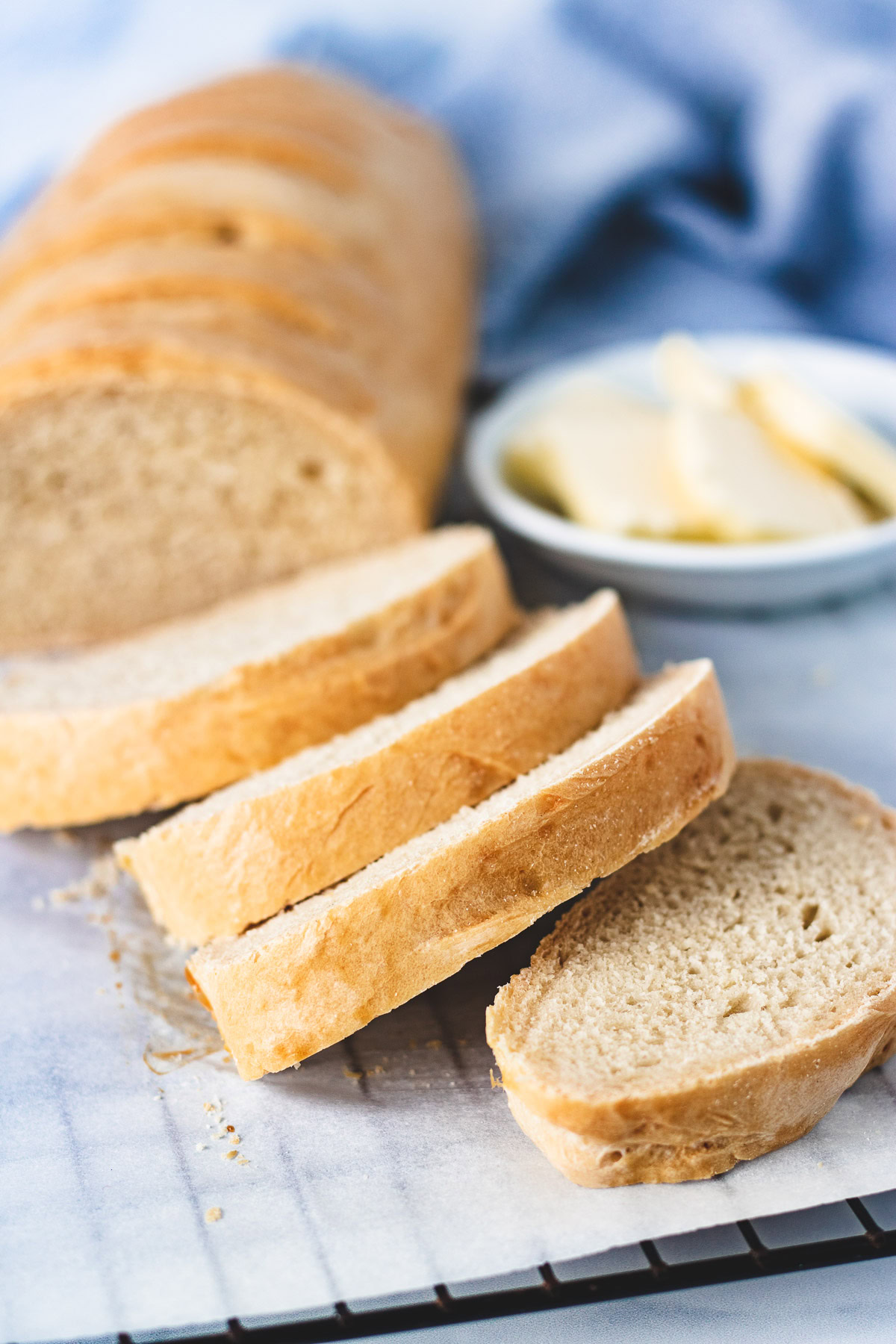 Sliced French bread with butter in the background.