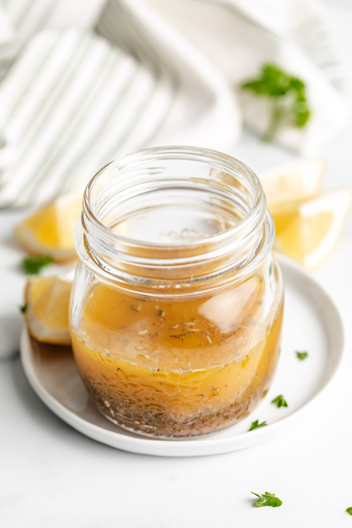 Italian dressing in a jar with lemon and parsley.