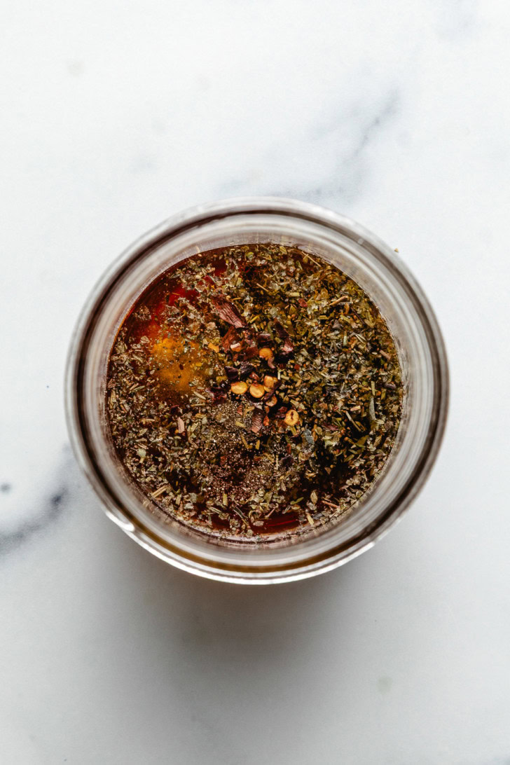 Italian dressing ingredients in a glass jar.