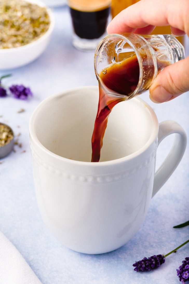 Espresso being poured into a white mug for a lavender latte.