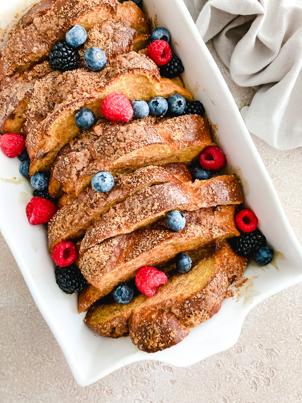 Baked french toast topped with raspberries, blueberries, and blackberries.