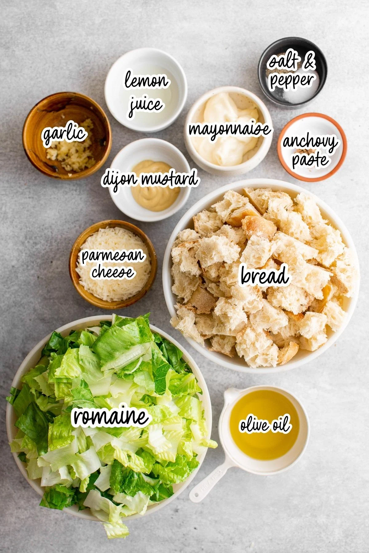 Caesar salad ingredients labeled on a gray surface.