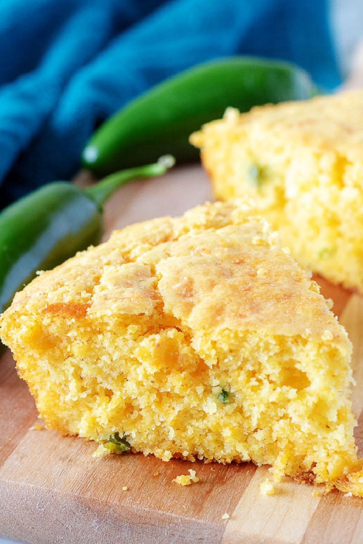 Slices of jalapeno cornbread on a wooden board.
