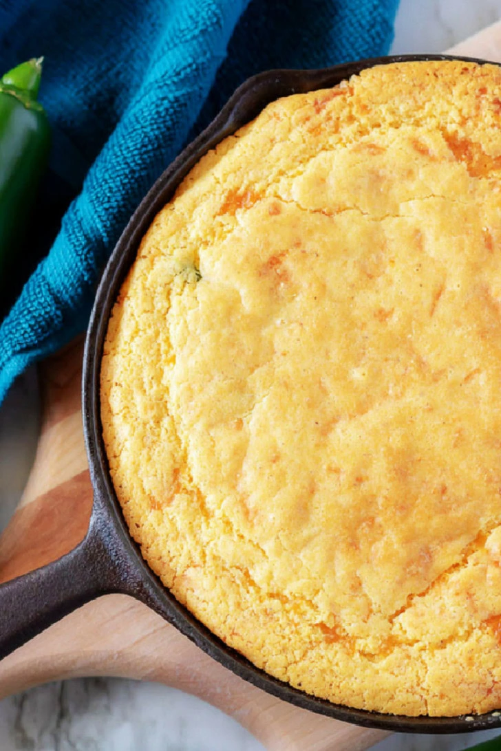 Overhead view of cornbread in a cast iron pan.