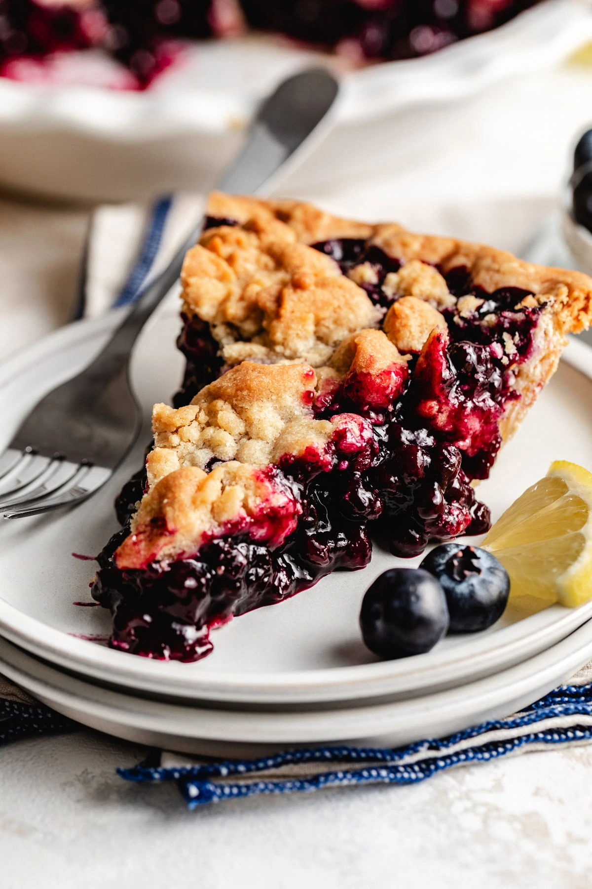 Blueberry pie filling and crumb topping in a sliced pie.