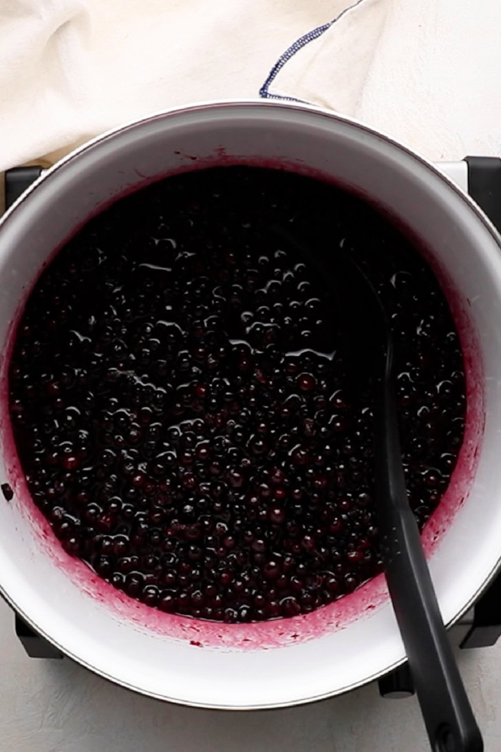 Thickened blueberry filling in a saucepan.