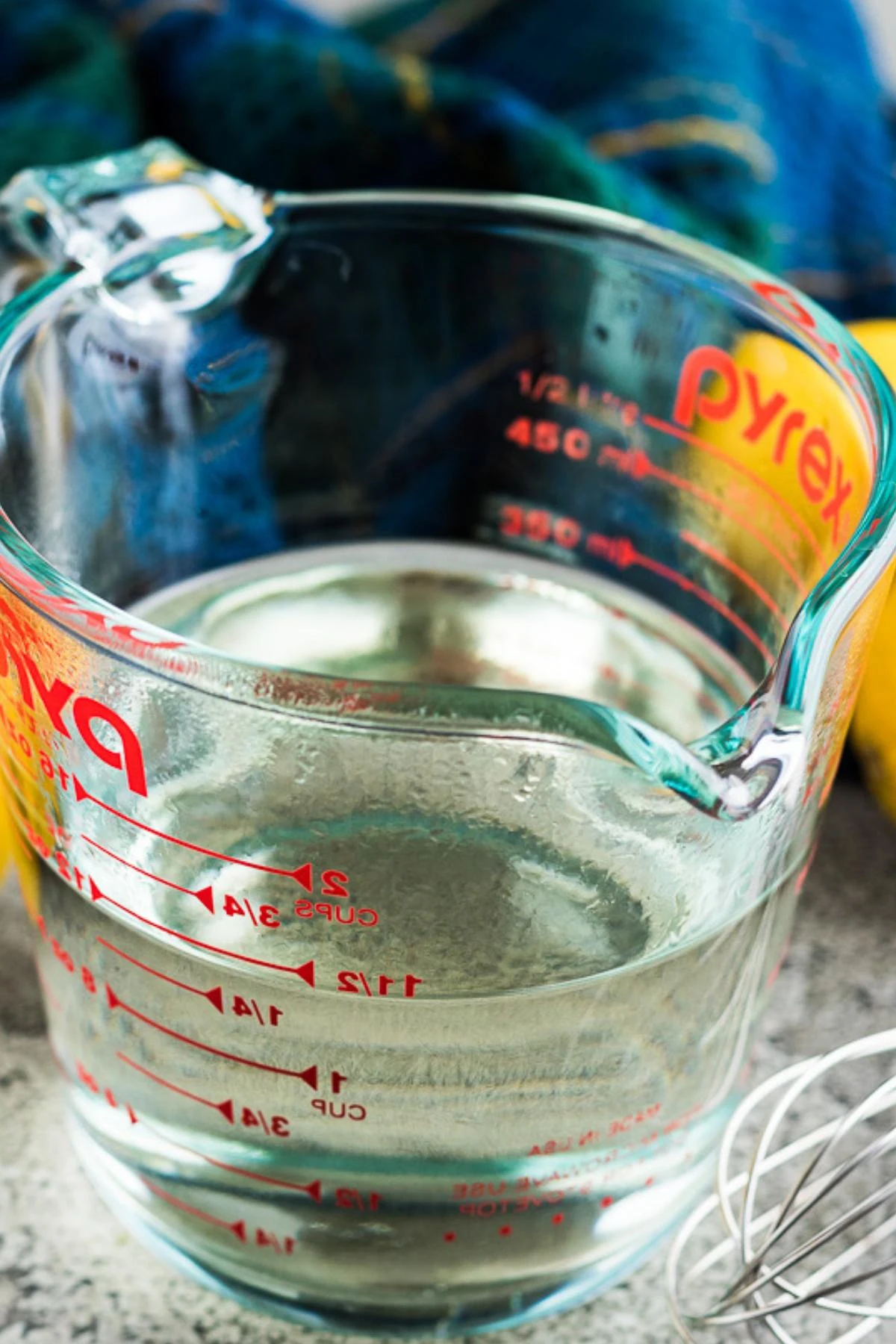 Close up view of simple syrup in a glass measuring cup.