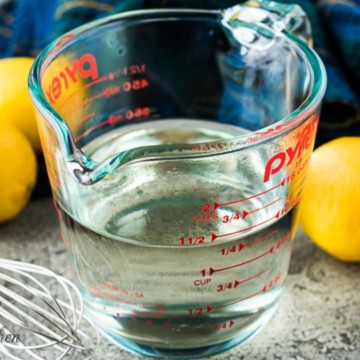 Glass measuring cup half full of freshly made simple syrup.
