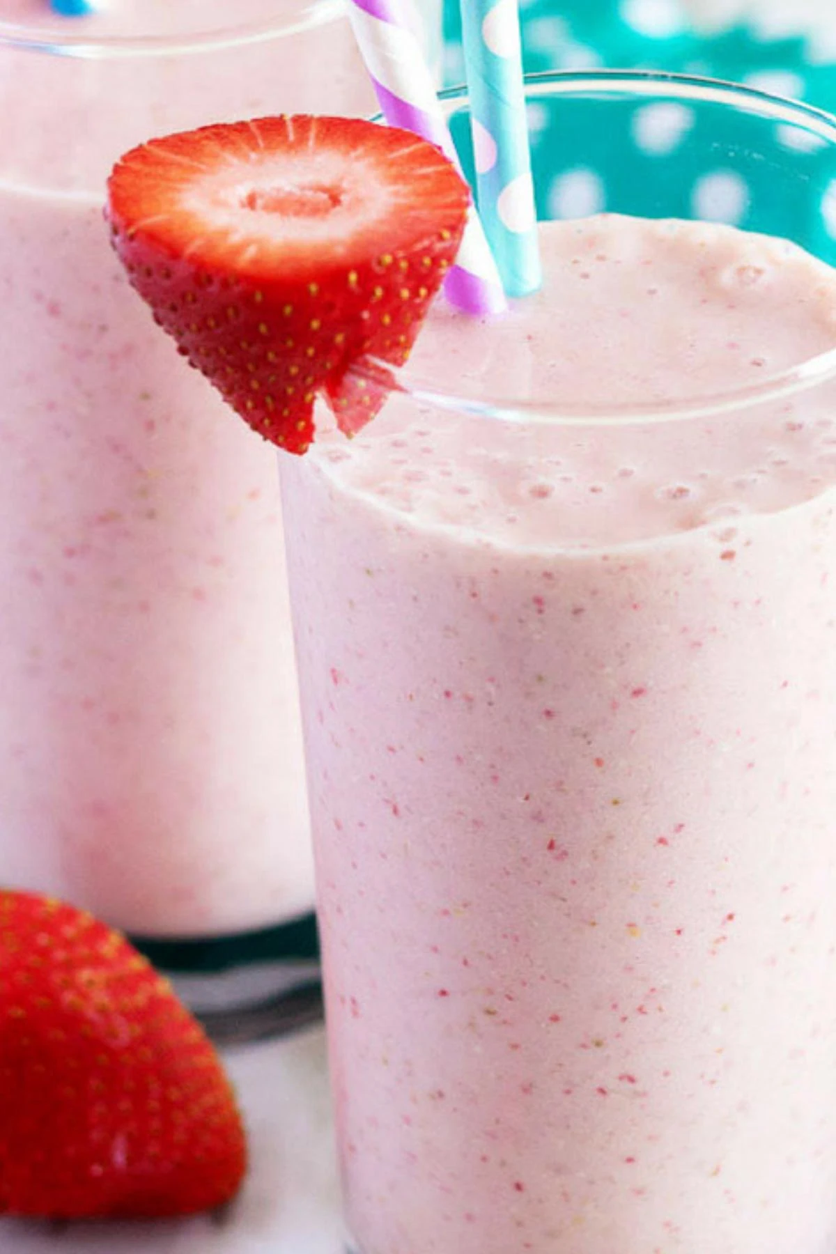 Close up view of a strawberry banana smoothie topped with a fresh strawberry.