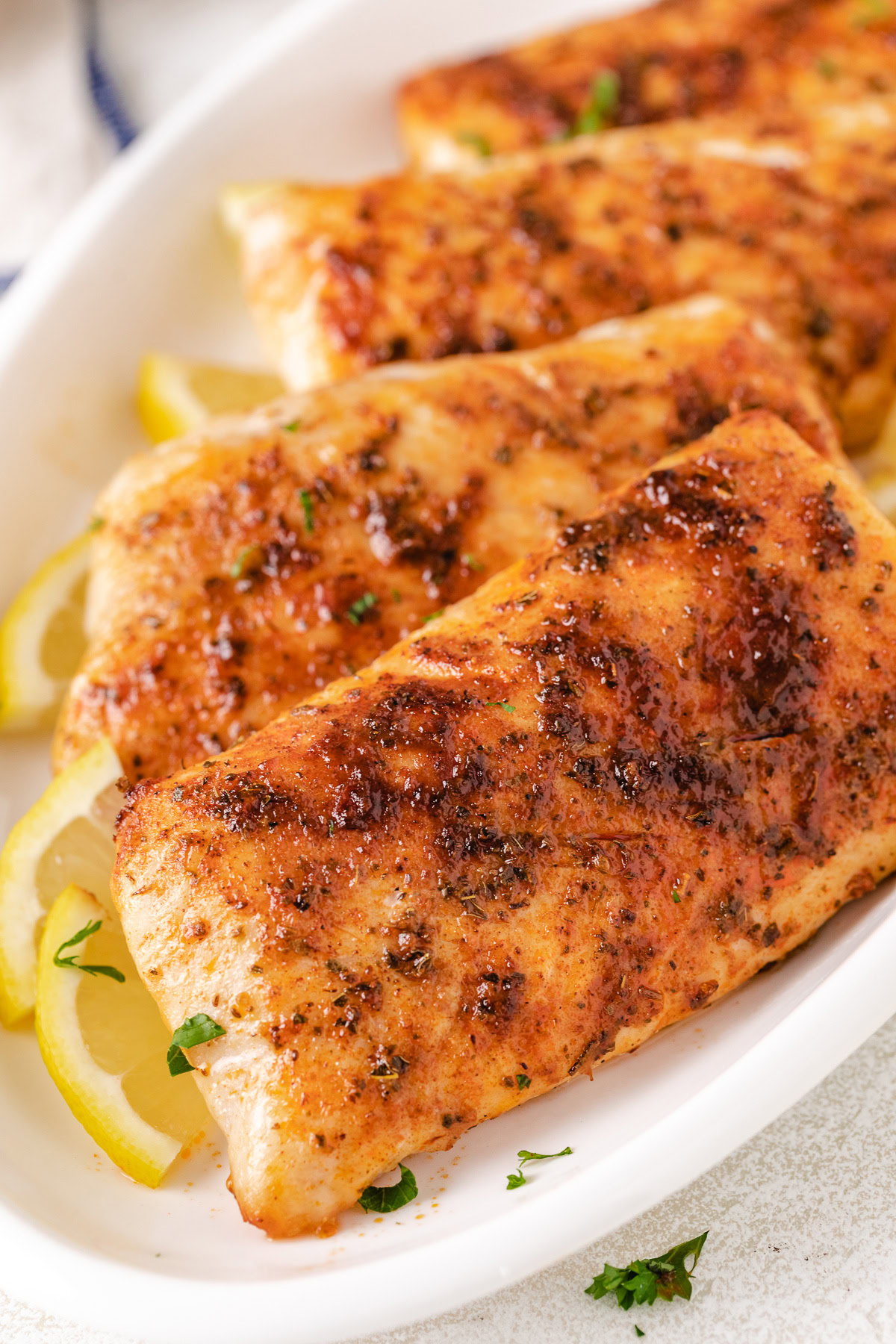 Close-up of air fryer mahi mahi with lemon and parsley.