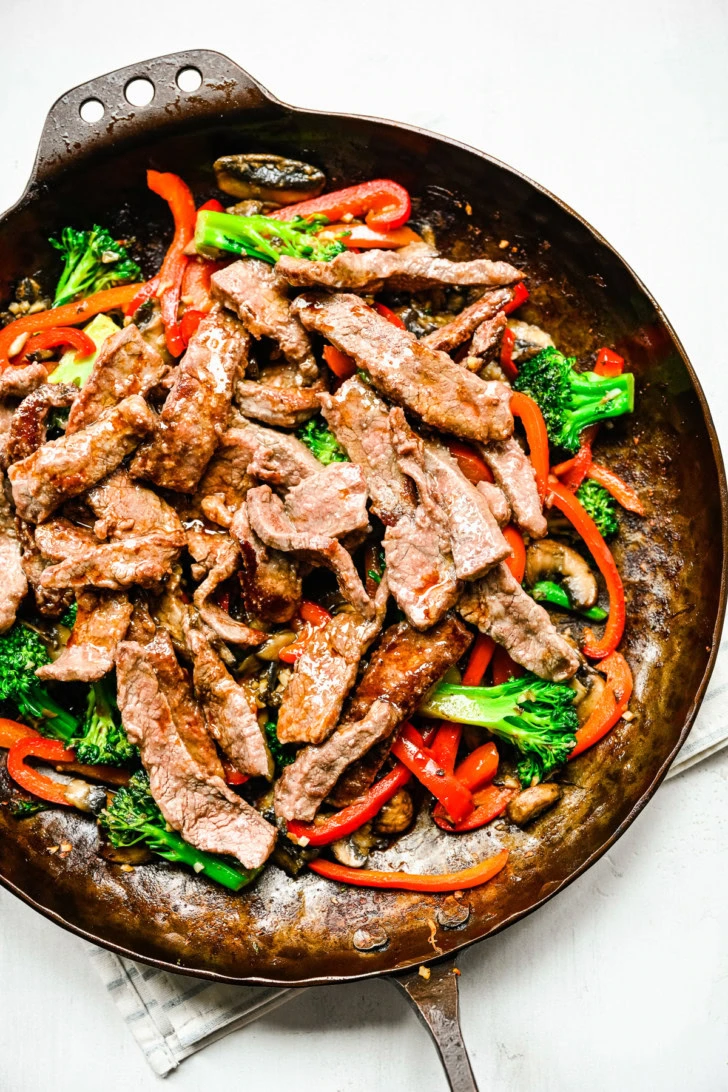 Saucy steak and vegetables topped with sesame seeds and green onions.