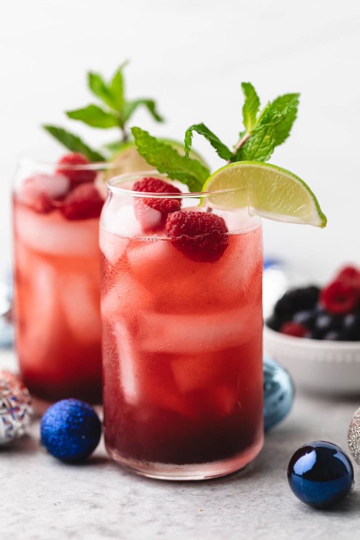 Fresh berries, mint, and lime in a glass.